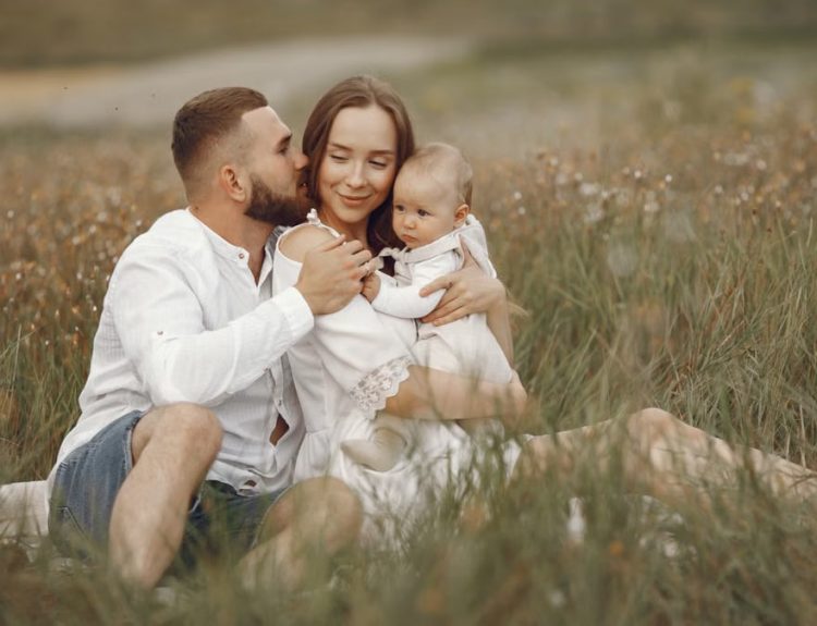 Happy family enjoying quality time in a serene meadow setting.